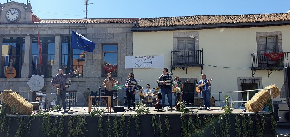 Ad Folkitum actuando de día en un festival folclórico, en un escenario decorado con balas de paja